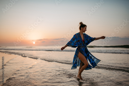 Young woman enjoying time at sea, dancing. #585835435
