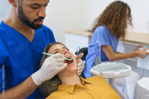 Dental examination of young woman at dental clinic.