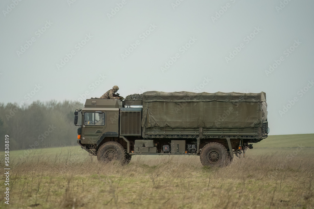 MAN SV 4x4 army logistics vehicle truck driving along a dirt track in action on a military exercise, Wilts UK