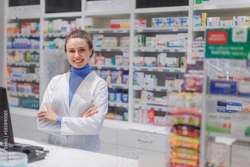 Portrait of young pharmacist selling medication in pharmacy.