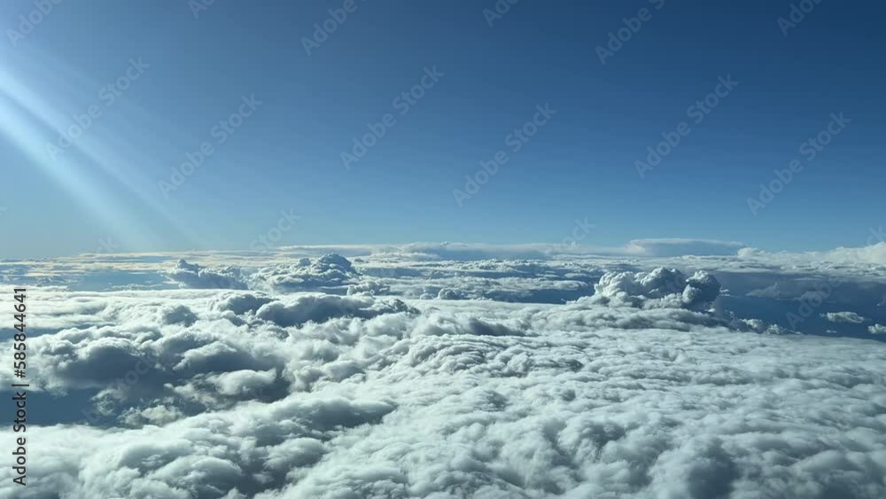 A pilot’s perspective: flying over a stormy and turbulent sky in a spring sunny day. Blue and sunny sky with some sunbeams on the left side. Flying at 12000m high A pilot’s perspective: flying over a stormy and turbulent sky in a spring sunny day. Blue and sunny sky with some sunbeams on the left side. Flying at 12000m high