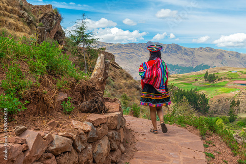 Fotografiet Peruvian indigenous quechua woman in traditional clothing walking along Inca Trail, Sacred Valley, Cusco, Peru