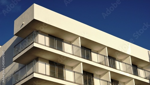 corner of white building facade with balconies