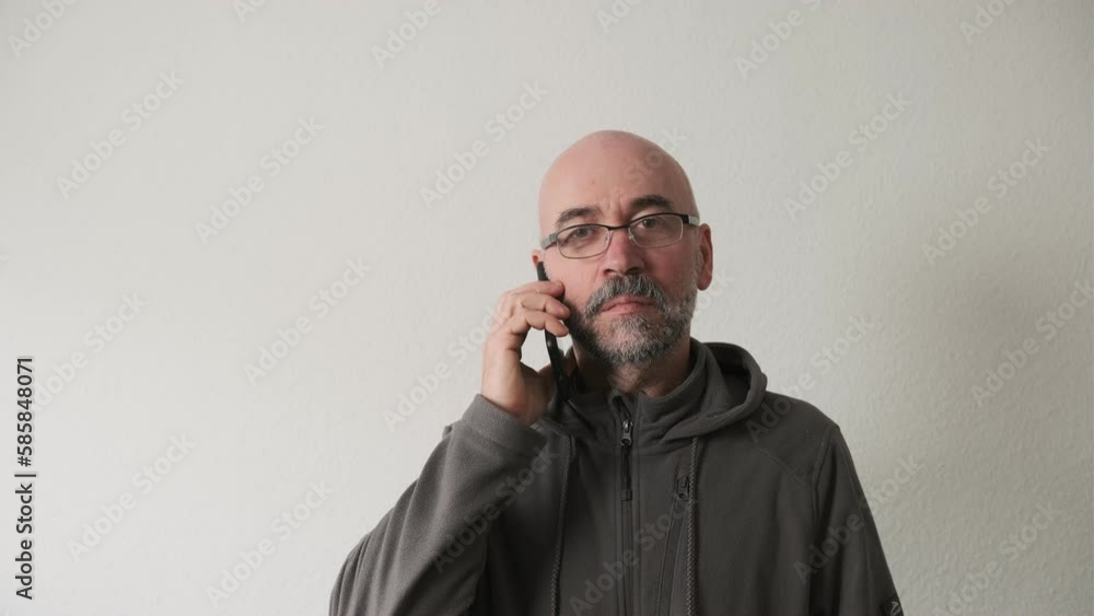 Bearded man talking emotionally on smartphone in studio on white background Bearded man talking emotionally on smartphone in studio on white background