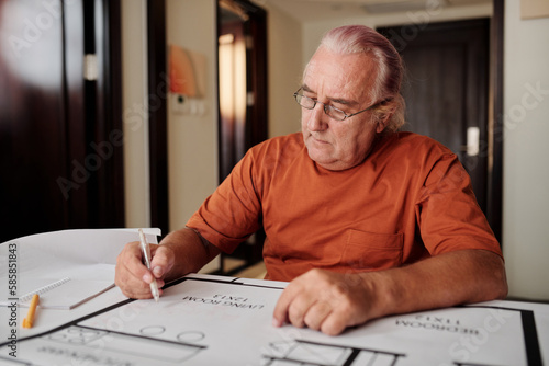 Senior man drawing construction plan for his house when planning renovation