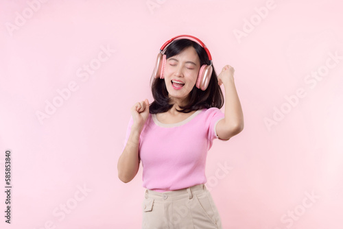 Smile pretty model person listen music song and enjoy dance with wireless headphone online audio radio sound. Positive fun exited joyful youth female woman sing on pink isolated background studio