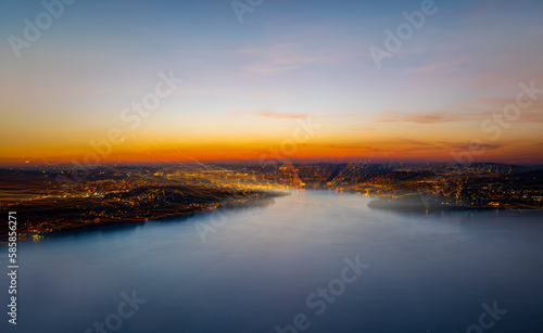 Aerial View over Mountain and Lake and City Lucerne in a Dusk with Light Trails in Lucerne, Switzerland. © Mats Silvan