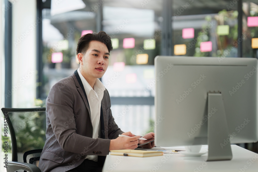 Smiling Asian Banker makes financial report and studies annual figures, analyzes profits. Accountant checks status of financial Smiling Asian Banker makes financial report and studies annual figures, analyzes profits. Accountant checks status of financial