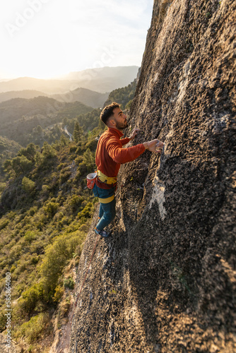 man climbing at sunset in the mountains with the forest in the background, copy space, business, security, trust © VICTOR