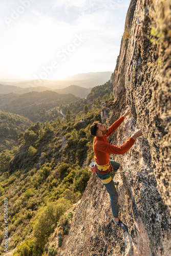 man climbing at sunset in the mountains with the forest in the background, copy space, business, security, trust