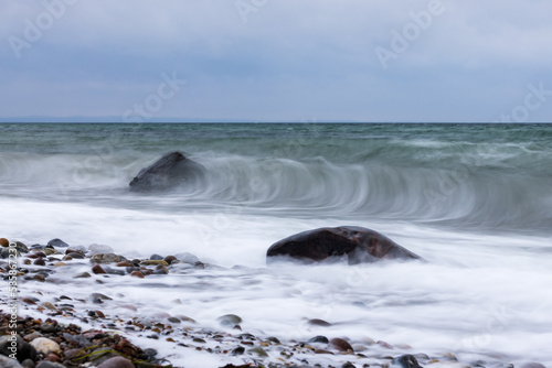 Steine im Wasser, von den Wellen umschlungen, Langzeitbelichtung