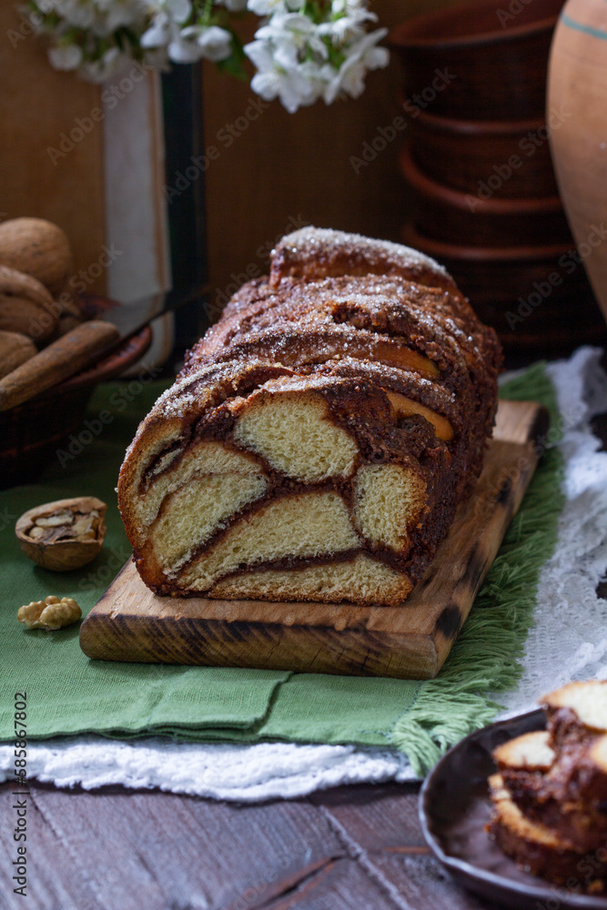 Traditional Easter bread with chocolate and nut filling on a wooden background.