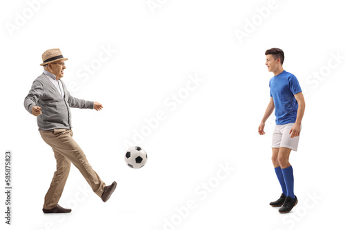 Canvas Print Full length profile shot of an excited elderly man kicking a ball to a football