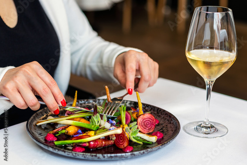 Canvas Print Detail of woman eating appetizing fresh mixed salad in fancy restaurant