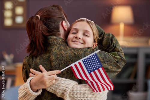 Obraz na płótnie Portrait of happy girl embracing mother coming home from military service