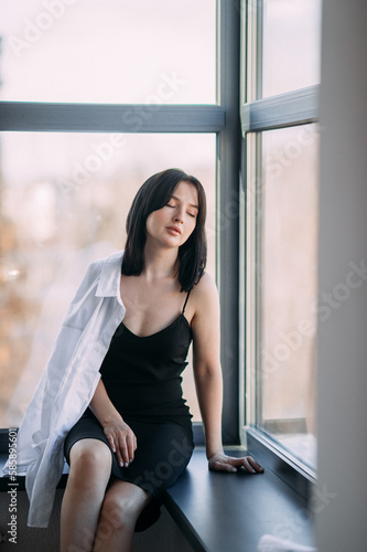 Portrait of a girl sitting near the window 4557.