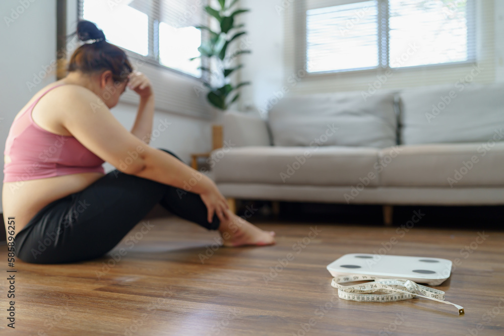 Obese Woman with fat upset bored of dieting Weight loss fail Fat diet and scale sad asian woman on weight scale at home weight control. Obese Woman with fat upset bored of dieting Weight loss fail Fat diet and scale sad asian woman on weight scale at home weight control.