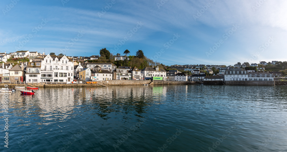 View of the pretty historic Cornish fishing village of Polperro with the harbor, fishing boats and fisherman cottages in sunshine