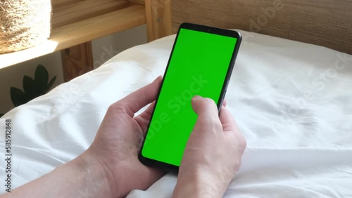 A man is holding a phone with a green screen. Online training. Communication online. phone in hand