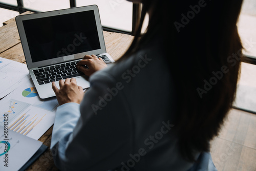 Attractive smiling young asian business woman work at home office, Asian woman working on laptop computer holding tablet.