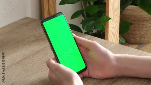 A man is holding a phone with a green screen. Online training. Communication online. phone in hand . kid