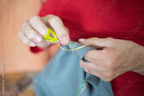 Senior woman sewing embroidery at home