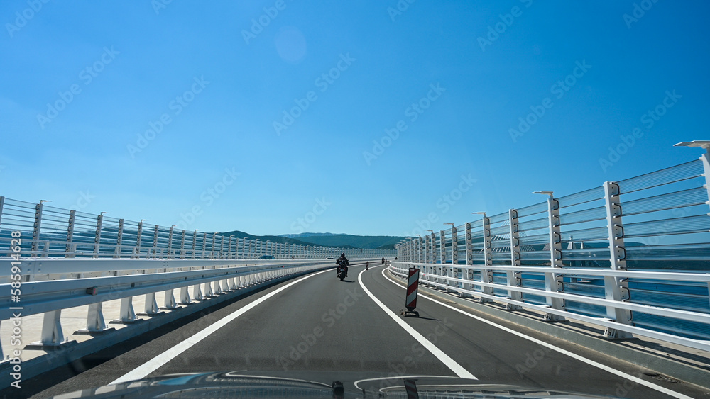 The big bridge over the sea. White bridge. Motorcycle on bridge. Peljesac bridge, Croatia. 