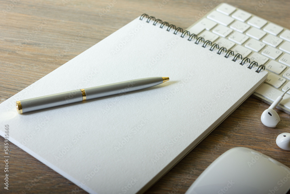 Notepad with pen and keyboard on wooden table with headphones Notepad with pen and keyboard on wooden table with headphones