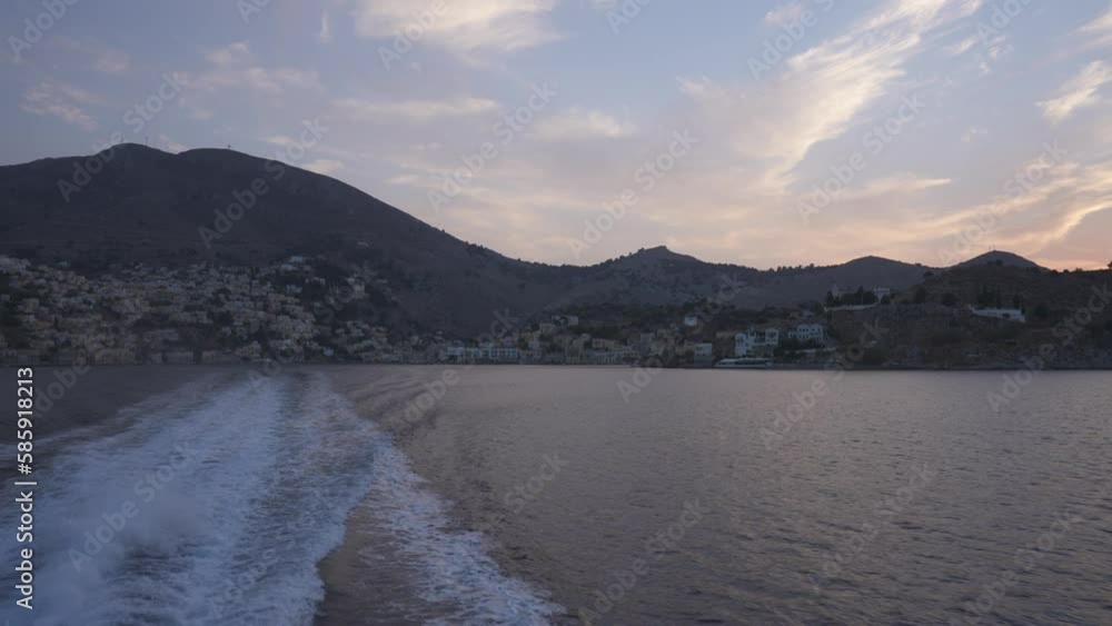 Onboard ferry shot of colourful houses while leaving Symi at sunset, Symi Town, Symi Island, Dodecanese Islands, Greek Islands, Greece, Europe Onboard ferry shot of colourful houses while leaving Symi at sunset, Symi Town, Symi Island, Dodecanese Islands, Greek Islands, Greece, Europe