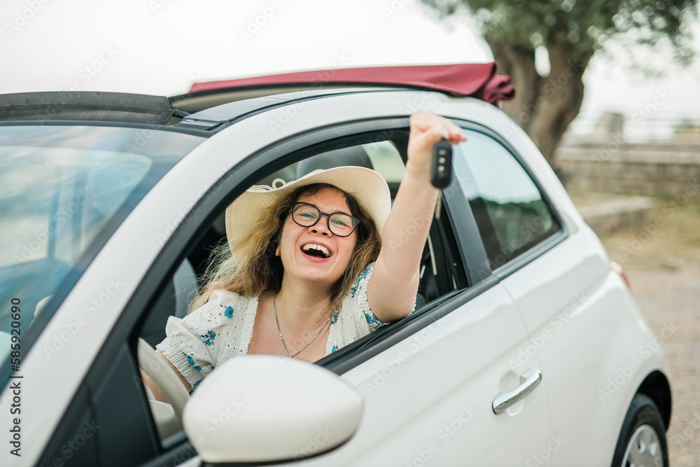 Young happy woman showing key of new car - Rental and buy new car concept
