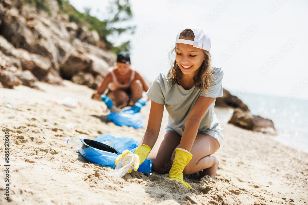 Teen Volunteer Collecting Trash On The Beach Teen Volunteer Collecting Trash On The Beach