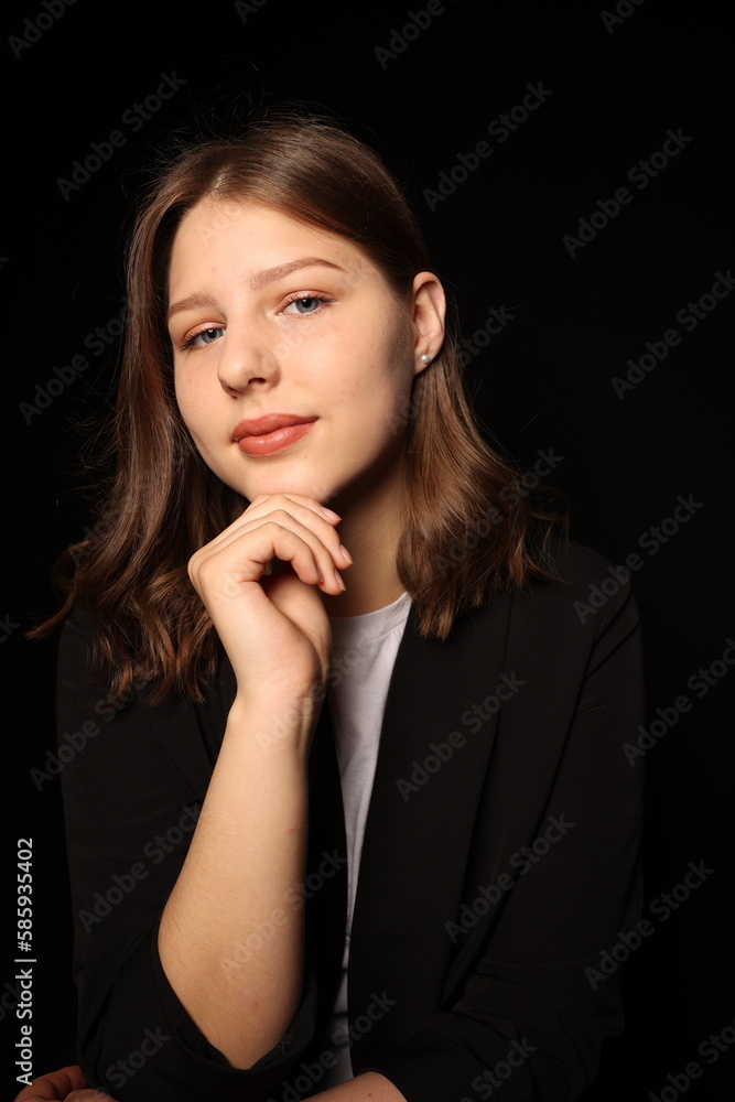 portrait of a beautiful young brunette woman in a black blouse on a black background. strict portrait of a girl on a black background portrait of a beautiful young brunette woman in a black blouse on a black background. strict portrait of a girl on a black background