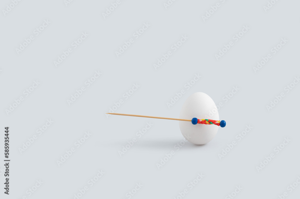 Minimal Easter time concept with white egg and toothpick used as spear or sword. Minimal Easter time concept with white egg and toothpick used as spear or sword.