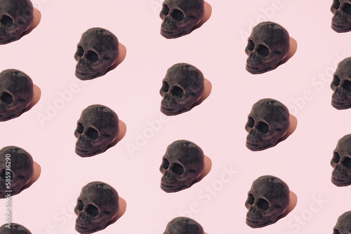 A wax skeleton head on a pink background. Pattern.
