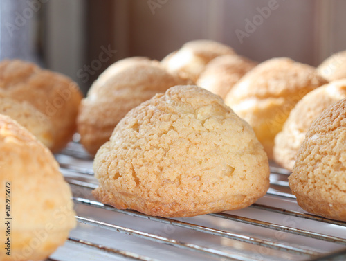 Close up of French cream puff crack bun (Choux au Craquelin) in a baking tray. It's a traditional French dessert base of savory little choux dough bun  photo