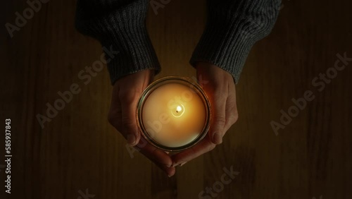 Wallpaper Mural Female hands holding candle appear in the frame, over a wooden table background. Moment of sorrow and grief. Spiritual significance of holy sacrament brings peace and meditation, inspiring to pray. Torontodigital.ca