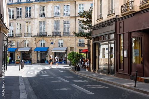 Cozy street with tables of cafe in Paris, France. Cityscape of Paris. Architecture and landmarks of Paris