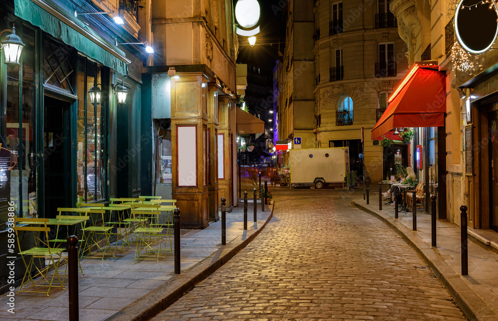Fototapeta premium Cozy street with tables of cafe in Paris at night, France. Architecture and landmark of Paris. Paris cityscape