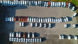AERIAL TOP DOWN: Full parking lot of brand new motorhomes ready for sale or rent