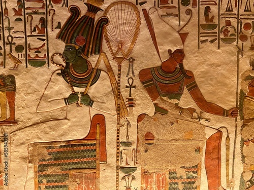 The colorful designs in Queen Nefertari tomb in Queens valley in Luxor - Osiris and Atum receiving offerings from Nefertari