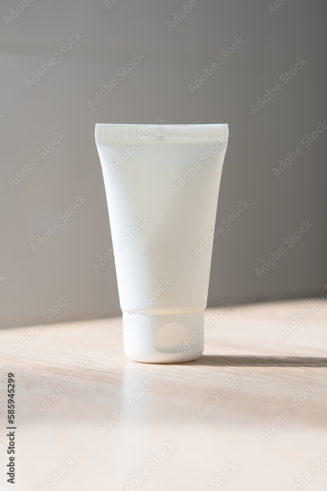 White cream tube on wooden table mock-up, beauty and care product packaging template White cream tube on wooden table mock-up, beauty and care product packaging template