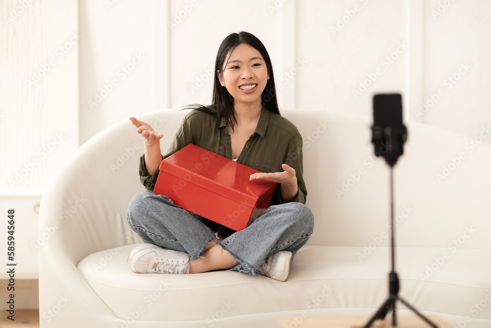 Happy asian woman influencer holding red shoe box, streaming Happy asian woman influencer holding red shoe box, streaming