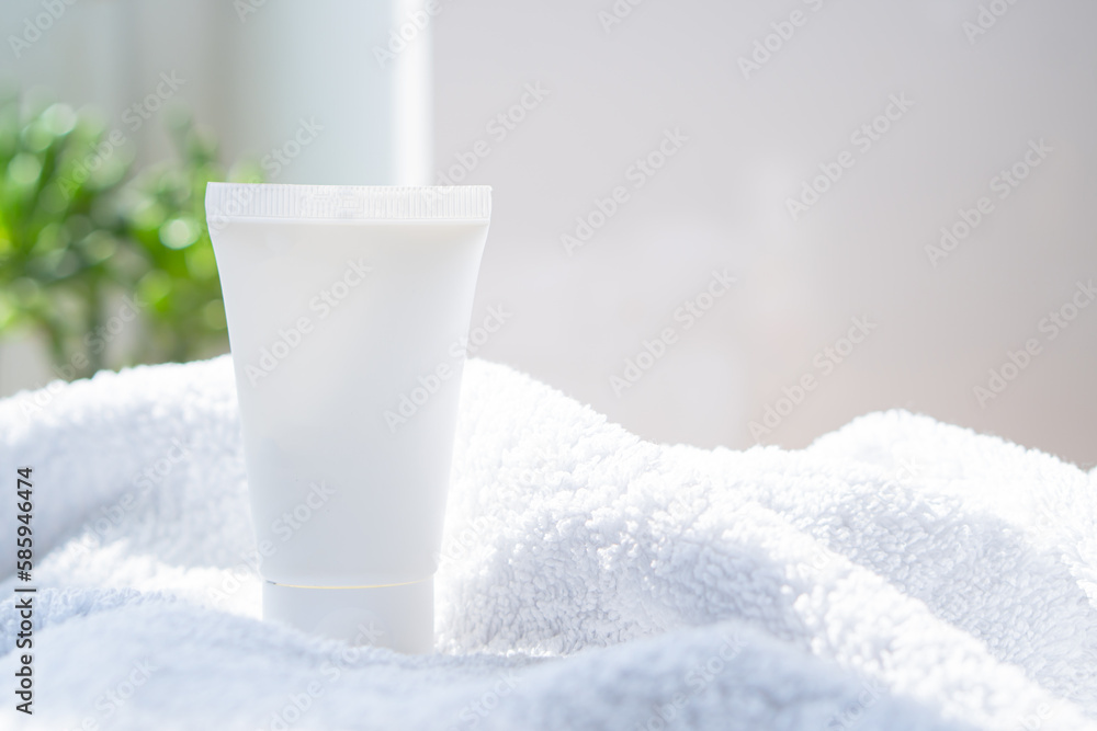 White cream tube and towel in real room interior mock-up, beauty and care product packaging template White cream tube and towel in real room interior mock-up, beauty and care product packaging template