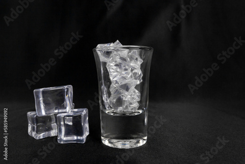 A glass shot with ice isolated on black.