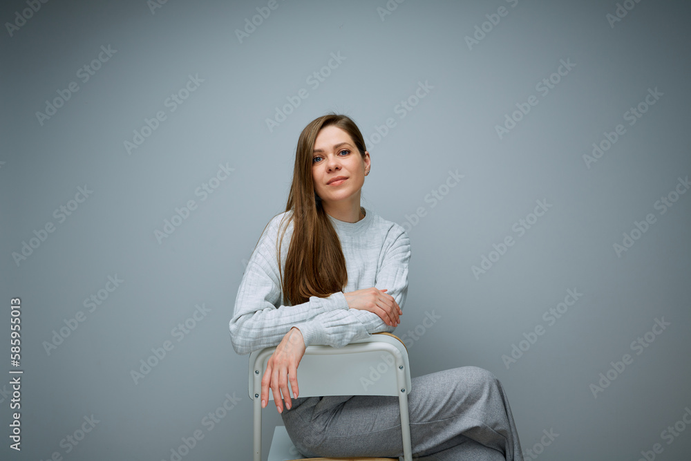 Portrait of serious woman sitting on chair back view. Portrait of serious woman sitting on chair back view.