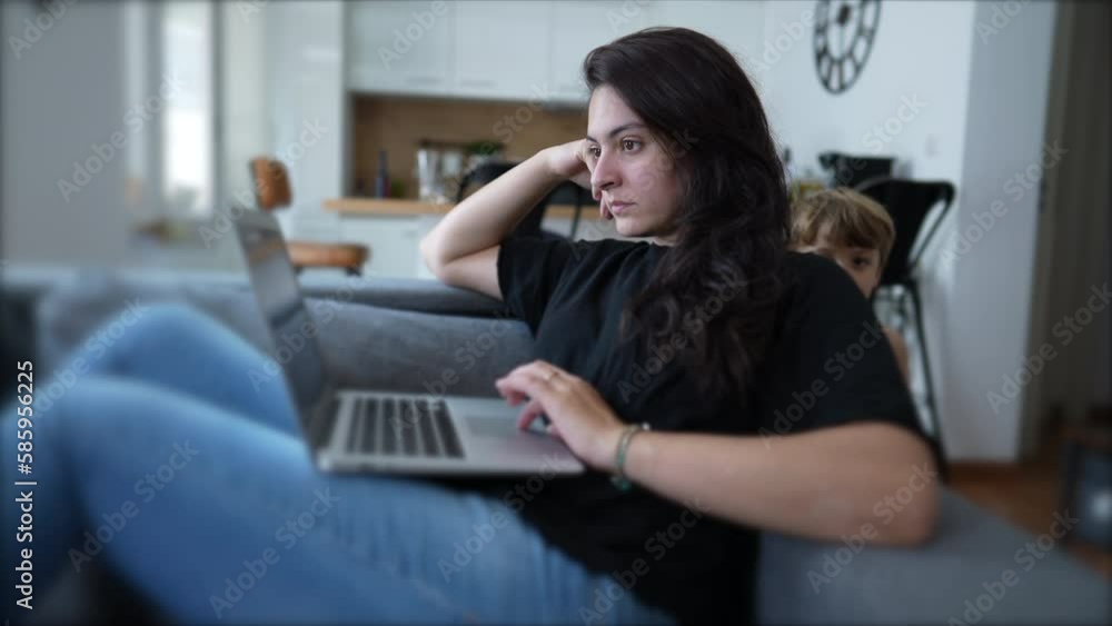 Woman browsing internet with laptop computer sitting on couch at home. Person looking at screen. Modern lifestyle Woman browsing internet with laptop computer sitting on couch at home. Person looking at screen. Modern lifestyle
