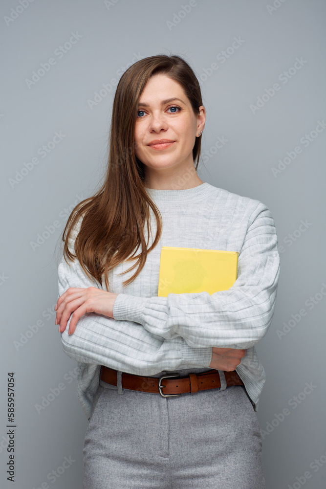 Fototapeta premium Young accountant woman holding yellow book. Isolated portrait.