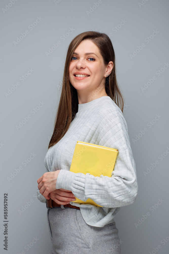 Adult student or teacher woman holding yellow book. Isolated portrait. Adult student or teacher woman holding yellow book. Isolated portrait.