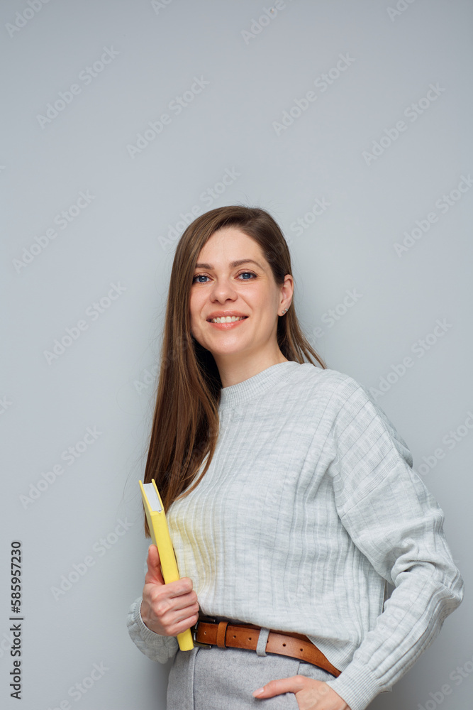 Adult student or teacher woman holding yellow book. Isolated portrait. Adult student or teacher woman holding yellow book. Isolated portrait.