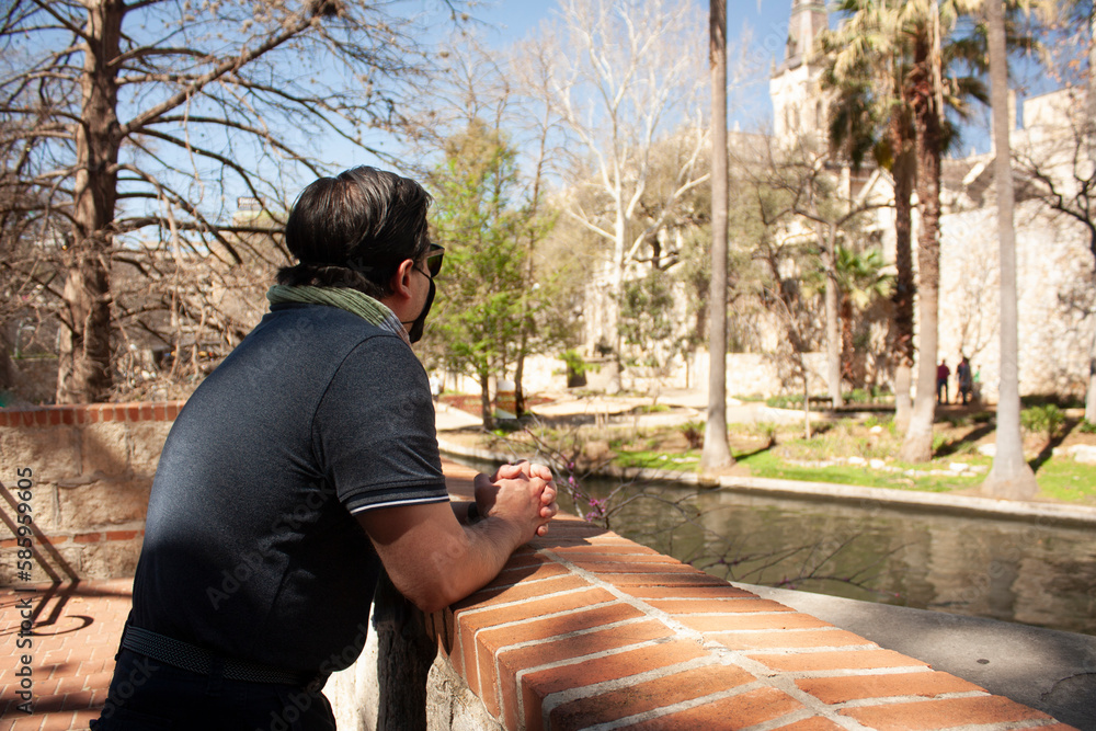 Street on the banks of the River walk in San Antonio Texas observed by Caucasian Latino man wearing mask and glasses Street on the banks of the River walk in San Antonio Texas observed by Caucasian Latino man wearing mask and glasses